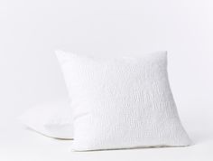 two white pillows sitting on top of each other