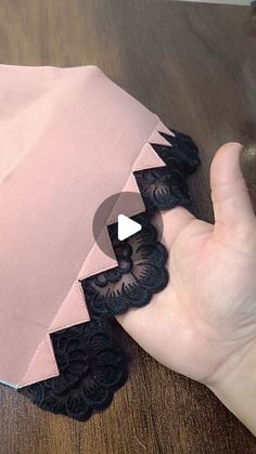 someone is holding an umbrella with black lace on the edges and pink fabric around it