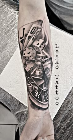 a man's arm with a clock and dice tattoo on it, in black and white