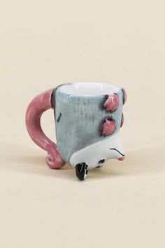 a ceramic coffee cup with pink and grey designs