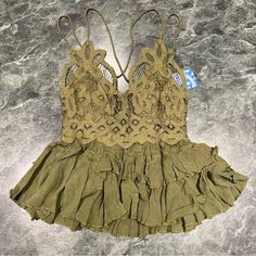 Intimately Free People Size Xs Cami Top Lace Crochet Olive Sparrow Green Ruffle Elevate Your Bohemian Wardrobe With This Beautiful Free People Intimately Adella Cami Top. The Top Features A Stunning Lace Fabric Type With A Delicate Ruffle Accent, Perfect For Any Occasion. The V-Neckline And Strappy Sleeve Type Add A Touch Of Sophistication, While The Adjustable Strap Feature Ensures A Comfortable Fit. This Olive Sparrow Green Camisole Comes In Xs Size, Regular Fit, And Is Made Of A Combination O Fitted V-neck Camisole With Ruffles, Lace V-neck Camisole For Vacation, Lace Tops With Ruffles For Vacation, Fitted Vacation Tops With Delicate Straps, Summer Lace Tops Bra-friendly, Summer Lace Top Bra Friendly, Beach Tops With Built-in Bra In Lace, Beach Camisole With Ruffles, Beach Top With Built-in Bra Made Of Lace