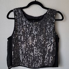 Nwt Walter Baker Finn Sequin Sleeveless Top Size: Large, Color: Black/Silver Scoop Neckline Cropped Boxy Fit All-Over Vertical Sequins And Beading Embellishments Sheer Panels At Sides Lined Extra Sequins And Buttons Attached 100% Polyester Across Chest: Approx. 18.25" Length: Approx. 19" Smoke/Pets Free Home Excellent Condition #F Glamorous Sleeveless Sequined Crop Top, Metallic Sleeveless Crop Top For Evening, Silver Sleeveless Crop Top For Evening, Black Sleeveless Glamorous Top, Black Sleeveless Top For Party Season, Glamorous Black Sleeveless Top, Glamorous Silver Tank Top For Party, Glamorous Silver Party Tank Top, Silver Sequined Sleeveless Crop Top