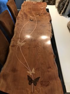 the table is made out of wood and has butterfly decorations on it's side