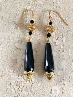 Onyx Earrings. Stunning black onyx earrings featuring a faceted teardrop black onyx stone accented with Gold over copper Bali style bead caps and 4MM black Swarovski crystals.  Earwires are gold filled and measure 2 1/2 inches long. GIFT BOXED Elegant Onyx Drop Jewelry, Classic Black Single Earring, Elegant Black Long Drop Jewelry, Elegant Black Drop Plug Earrings, Gold Gothic Earrings For Parties, Black Drop Earrings For Evening, Black Drop Earrings For Formal Occasions, Elegant Onyx Dangle Earrings, Elegant Black Drop Earrings Jewelry