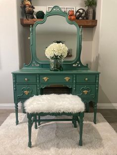 a green vanity with white flowers and a mirror