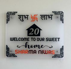 a glass sign that says welcome to our sweet home, shama niwas on it