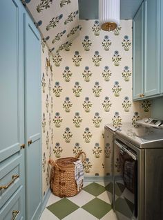 a washer and dryer in a small room with wallpaper on the walls