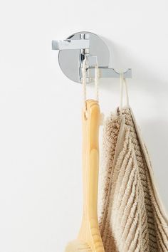 two towels and a brush hanging on a hook