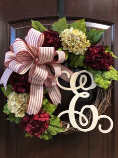 a wreath with the letter g and flowers on it