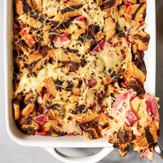 a casserole dish with meat, cheese and bread toppings in it on a table