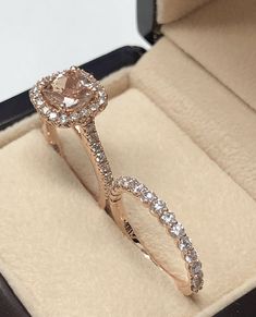 an engagement ring in a box with diamonds on the band and inside it is pink gold