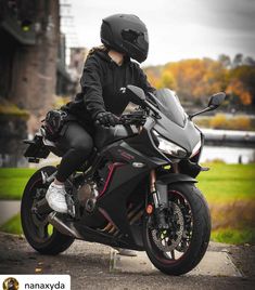 a woman sitting on top of a black motorcycle