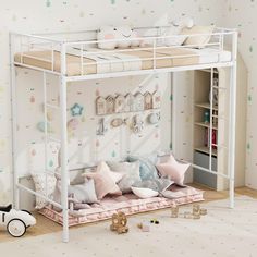 a white bunk bed with pink and blue pillows on the bottom shelf, underneath it