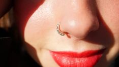 a woman's nose with a piercing on her left side and the word love written in it