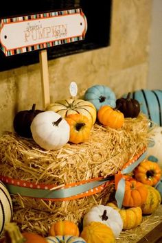 pumpkins and gourds are sitting on hay in front of a sign that says happy pumpkin