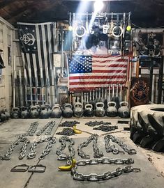 an old garage filled with lots of chains and other things in front of the american flag