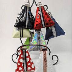 four purses are hanging on a rack with polka dots and ribbons attached to them