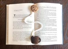 an open book with a crocheted button on it