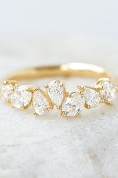 a gold ring with five pear shaped diamonds