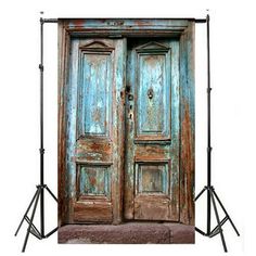 an old wooden door is shown in front of a tripod light stand and backdrop