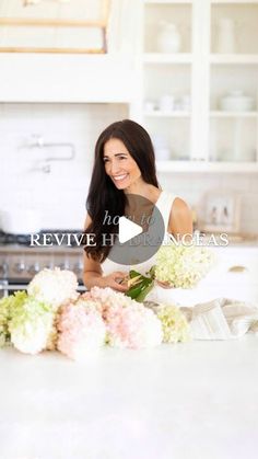 a woman standing in front of a counter with flowers