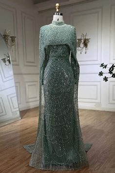 a dress on display in a room with white walls and wood flooring, it's all covered in sequins