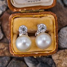 These elegant vintage 18k white gold earrings each feature a post set, cultured saltwater pearl, topped by a round old European cut diamond in a platinum bezel setting. The earrings measure 15.6mm long and are finished with non- pierced screw backs. Vintage White Diamond Earrings For Formal Occasions, Classic White Gold Pearl Earrings, Classic Platinum Pearl Earrings For Formal Occasions, Classic Silver Platinum Pearl Earrings, Classic Clip-on Diamond Earrings As A Gift, Anniversary White Gold Platinum Pearl Earrings, Vintage Round Platinum Diamond Earrings, Vintage Platinum Round Diamond Earrings, Platinum Round Pearl Earrings For Anniversary