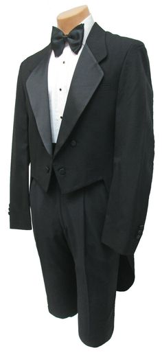 a black tuxedo suit with a white shirt and bow tie on a mannequin