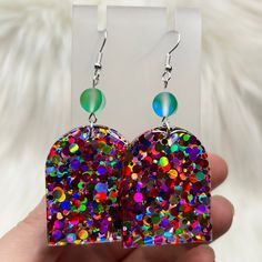 a pair of heart shaped earrings with multicolored sequins