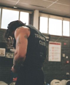 a man standing in a gym holding a frisbee