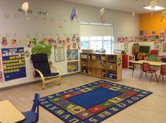 an empty classroom with chairs, tables and rugs