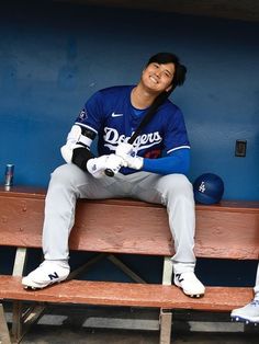 a baseball player sitting on top of a bench