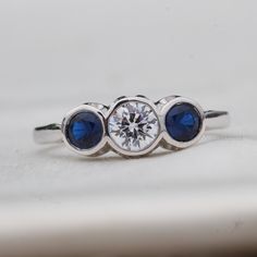 an engagement ring with three blue sapphire stones