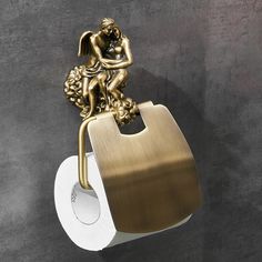 a gold toilet paper holder with an angel figurine on it