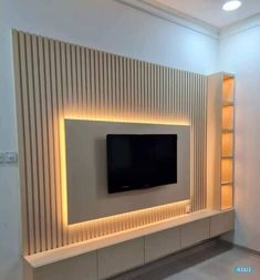 the television is mounted on the wall in the living room, and it's illuminated with leds