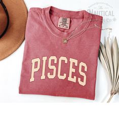 the pisces t - shirt is next to a hat and sunglasses