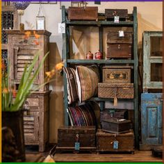 an old wooden shelf filled with lots of drawers and boxes next to a vase full of flowers