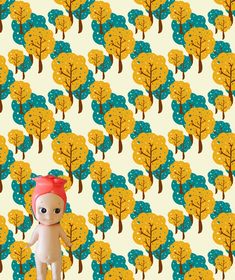 a small stuffed animal standing in front of a wallpaper with trees and leaves on it