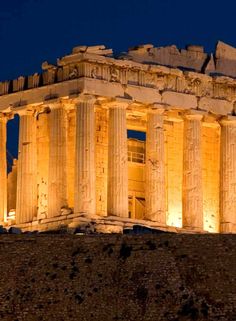 the parthenon is lit up at night with lights on it's sides