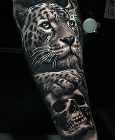 a man's arm with a black and white tattoo on it, featuring a leopard and a skull