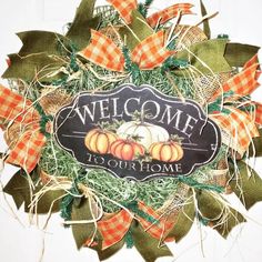 a welcome to our home wreath with pumpkins