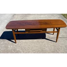 a wooden table sitting on top of a sidewalk