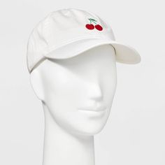 a white hat with cherries on the front and side, sitting on a mannequin head