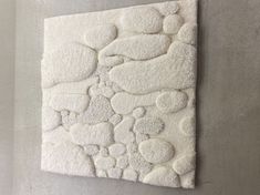 a white wall hanging on the side of a cement wall covered in bubbles and hearts