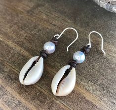 Natural cowrie shells dangle on genuine leather cord from sterling silver ear wires.  I have topped off the cowrie shell with a 7-8mm freshwater pearl.   These earrings are the ultimate attire for summer! You can select the color leather that you like best at checkout. Each pair of earrings comes in a gift box ready for giving or to keep for yourself. Care for your leather: Since I use all natural leather, it is beneficial to use shea butter to keep it moisturized.  You will only need a very sma Penny Bracelet, Boho Cuff Bracelet, Beach Jewelry Boho, Ocean Inspired Jewelry, Single Pearl Necklace, Abalone Earrings, Antler Necklace, Pearl Anklet, Wood Bead Bracelet