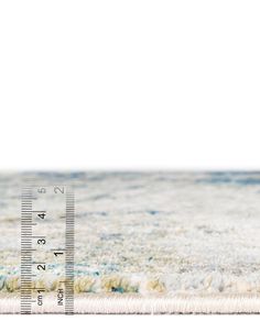 a white and blue rug with a ruler on it