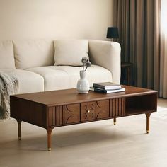 a living room with a white couch and wooden coffee table in front of a window