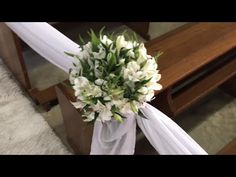 a bouquet of white flowers sitting on top of a wooden bench