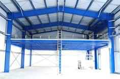 the inside of a building with blue metal beams