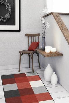 a room with a chair, rug and pictures on the wall